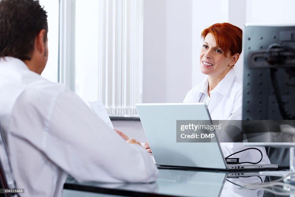 Mature Female doctor talking to her male patient