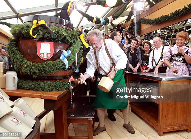 Munich's mayor Christian Ude opens the first beer barrel to start the Oktoberfest beer festival at the Schottenhamel beer tent during the opening day...