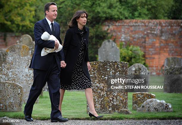 British Prime Minister, David Cameron , carries his baby Florence, as he and his wife Samantha arrive for the funeral of his late father Ian, at St...