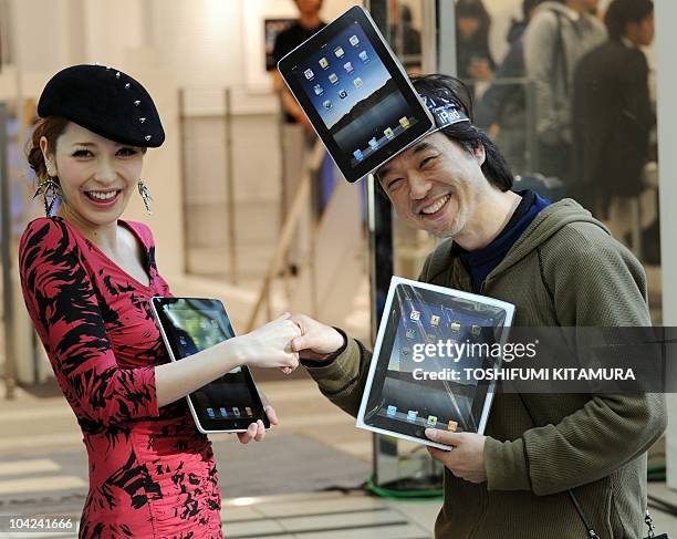 The first customer in the shop, Kazuki Miura , receives his iPad from fashion model, singer and actress Lena Fujii , as they start to go on sale at...