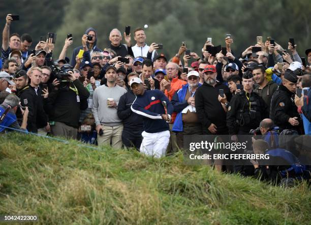 Golfer Tiger Woods plays a chip shot during his fourball match on the first day of the 42nd Ryder Cup at Le Golf National Course at...