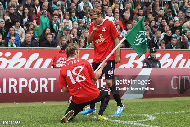 Marcel Risse of Mainz celebrates with his team mate Lewis Holtby after scoring his team's first goal during the Bundesliga match between Werder...