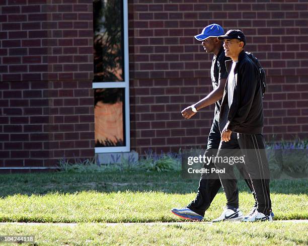President Barack Obama walks with his personal aide, Reggie Love, as the two arrive at Fort Leslie J. McNair's athletic facility for a morning game...