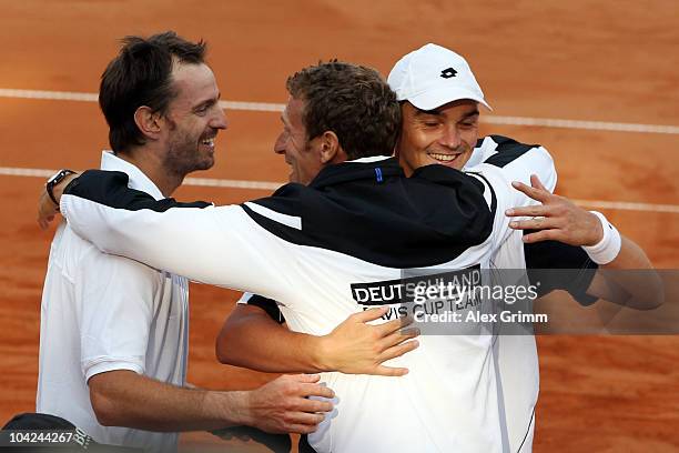 Christopher Kas and Andreas Beck of Germany celebrate with team captain Patrik Kuehnen after defeating Rik de Voest and Wesley Moodie of South Africa...