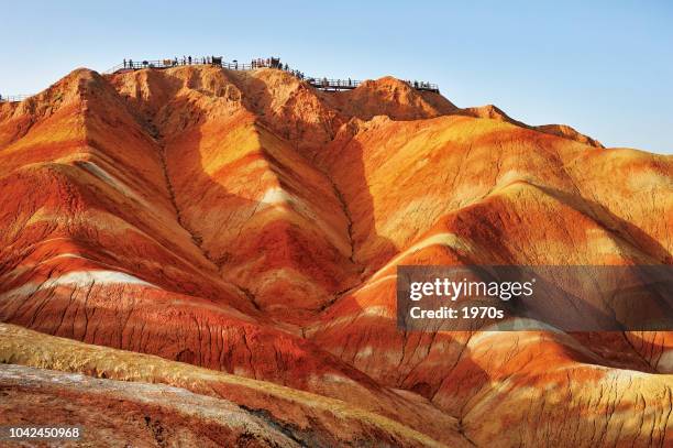 tourists on the stand to see the beautiful scenery of danxia landform  in the national geopark of zhangye, gansu, china. - national committee of the chinese people stock pictures, royalty-free photos & images
