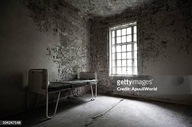 abandoned hospital with a bed in the corner - abandoned hospital stock pictures, royalty-free photos & images