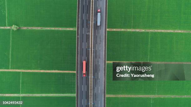 aerial view of road between green meadow - copy space - motor racing track aerial stock pictures, royalty-free photos & images