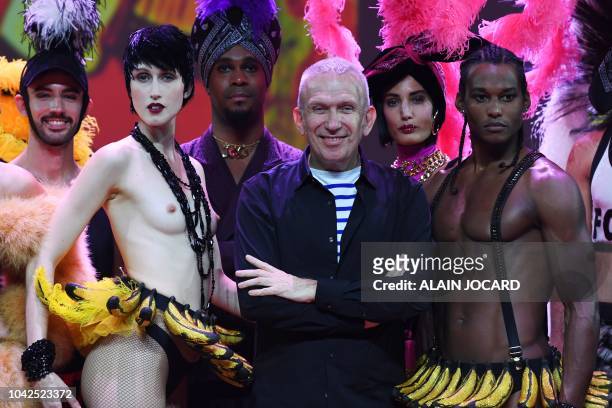 French fashion designer Jean-Paul Gaultier , flanked by US model Anna Cleveland , poses at the end of a preview of his Fashion freak show, at the...