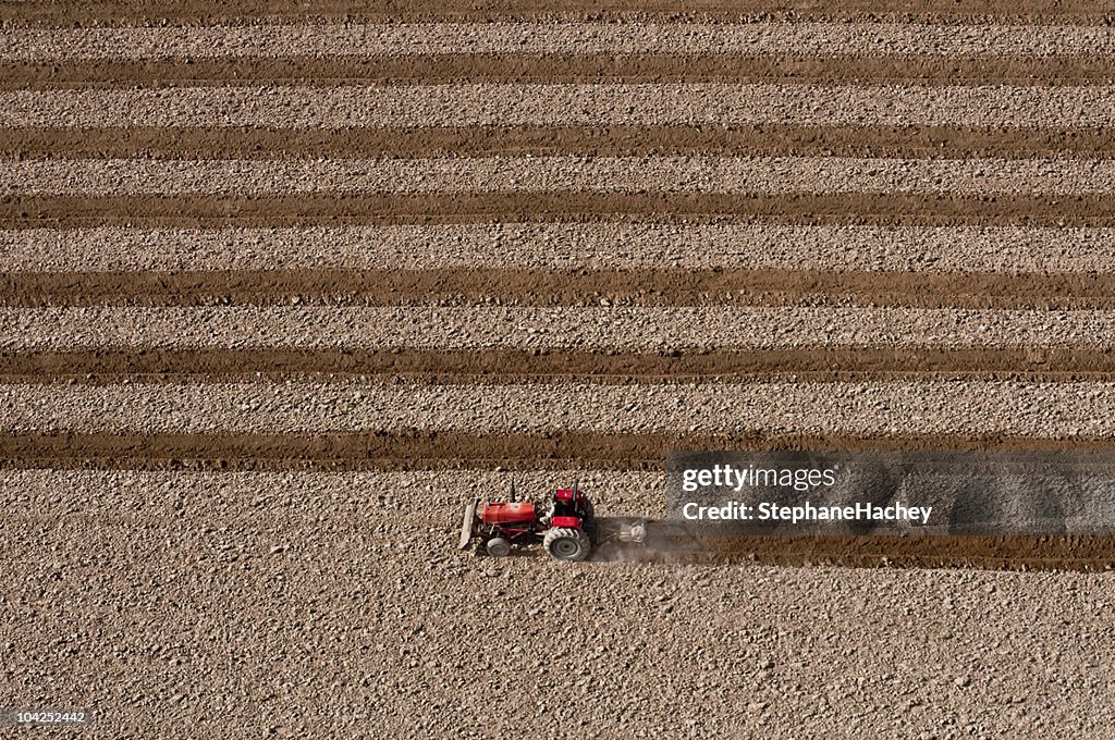 Red farm tractor plowing a field in Afghanistan