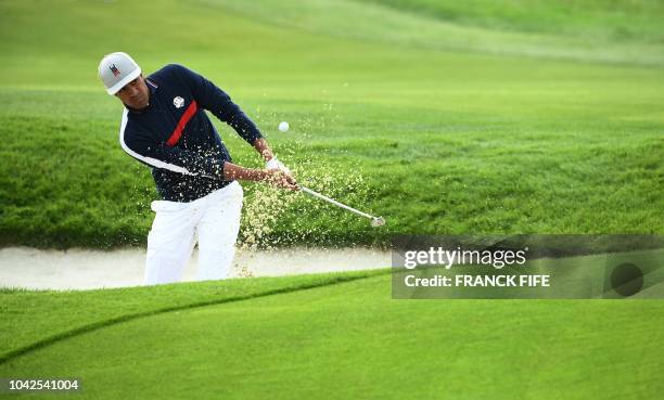 Golfer Tony Finau plays a shot out of a bunker during his fourball match on the first day of the 42nd Ryder Cup at Le Golf National Course at...