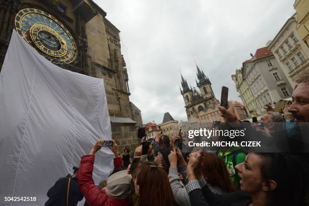 People attend the unveiling of the Pragues restored astronomical clock on the Old Town Square on September 28, 2018. - The 608-year-old clock was...