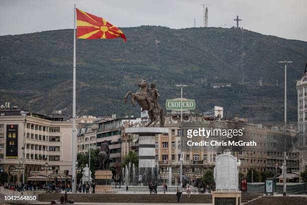 People walk in Macedonia Square in front of a statue of Alexander the Great on September 28, 2018 in Skopje, Macedonia. Macedonians will go to the...