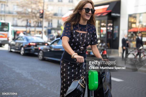 Guests are seen on the street arriving by scooter during Paris Fashion Week SS19 on September 27, 2018 in Paris, France.