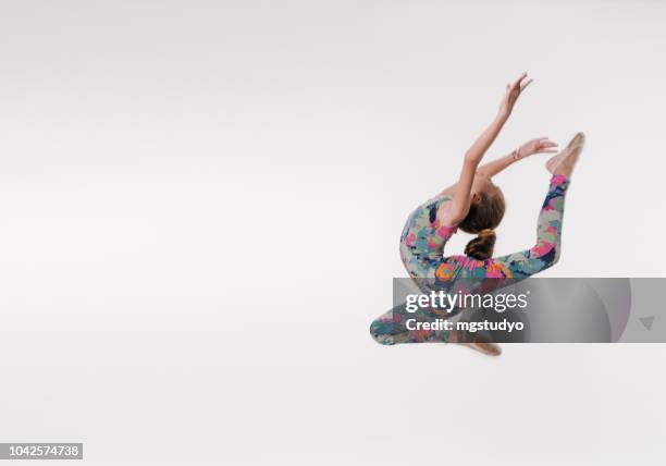 beautiful gymnast athlete teenage girl  jumping in studio - acrobat stock pictures, royalty-free photos & images