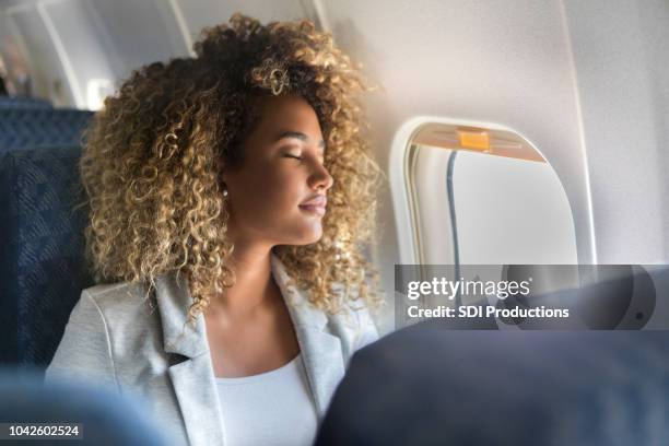 erste kommerzielle fluggesellschaft passagiere schläft in fensterplatz - business class flight stock-fotos und bilder