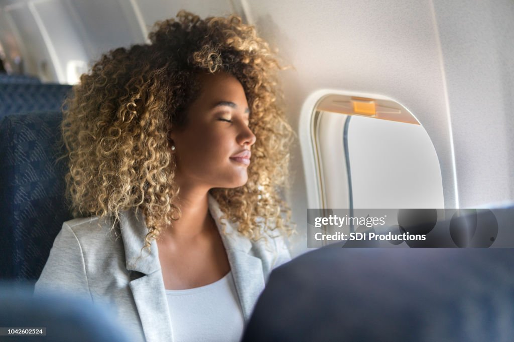 Commercial airline passenger sleeps in window seat
