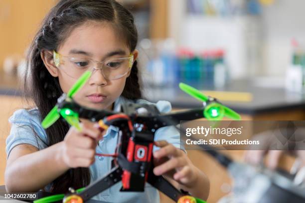 focused schoolgirl builds quadcopter - stem stock pictures, royalty-free photos & images