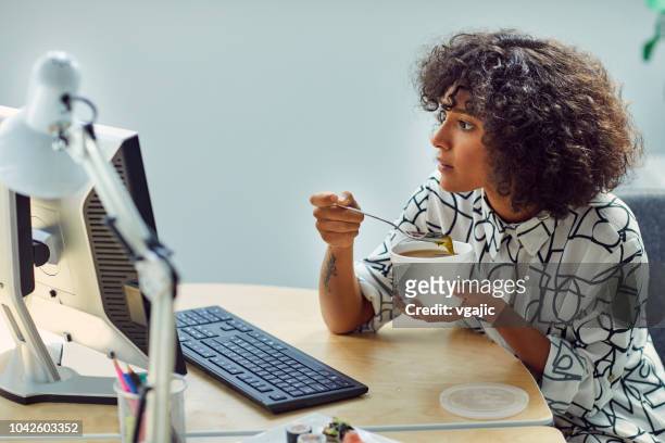 businesswoman eating in her office - smart casual lunch stock pictures, royalty-free photos & images