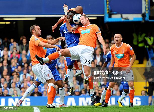 Michael Essien of Chelsea and Charlie Adam of Blackpool compete for a header during the Barclays Premier League match between Chelsea and Blackpool...