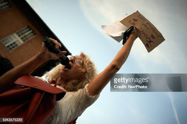 Woman speaks while holding a cardboard reading 'A child is a choice'. Women and men took to the streets of Toulouse for the International Safe...