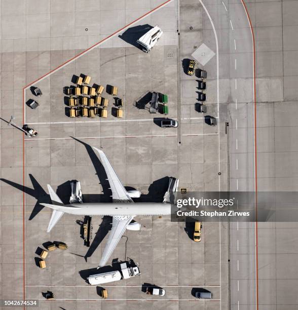 View from above commercial airplane being serviced, prepared on tarmac at airport