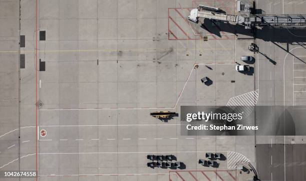 view from above airport service vehicles and passenger boarding bridge on tarmac at airport - passenger boarding bridge stock-fotos und bilder