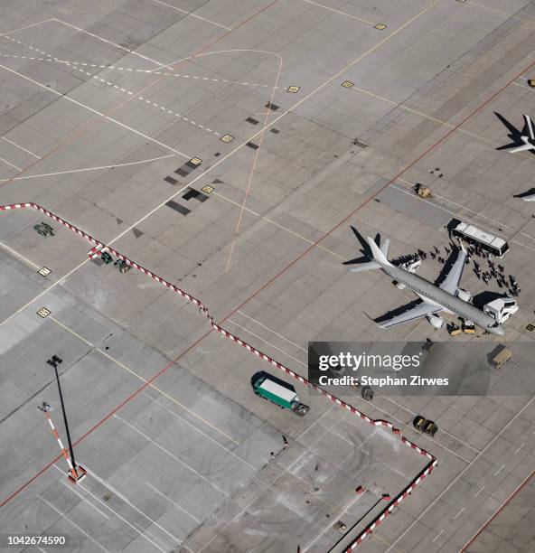 aerial view of passengers boarding commercial airplane on tarmac at airport - airport tarmac stock pictures, royalty-free photos & images