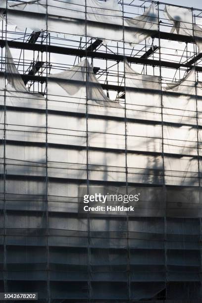 protective sheeting over highrise building under construction - plane stock-fotos und bilder