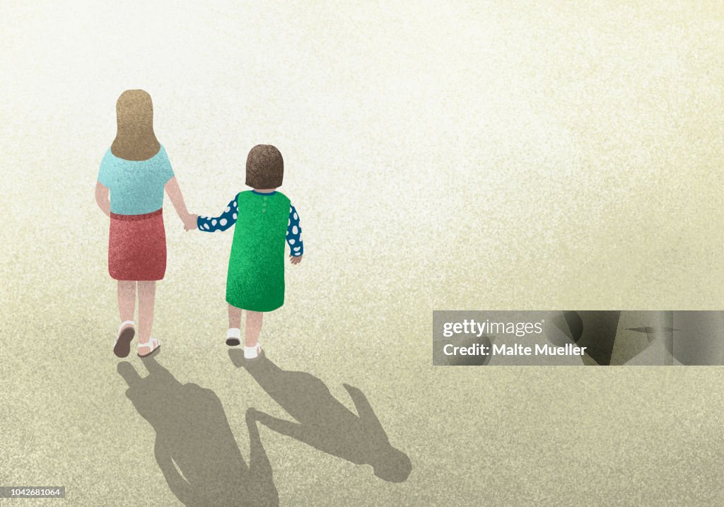 Mother and daughter holding hands on yellow background
