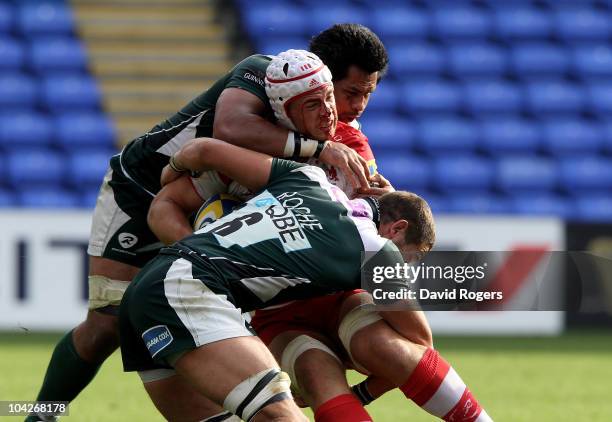 Dave Attwood of Gloucester is tackled by George Stowers and Kieran Roche during the Aviva Premiership match between London Irish and Gloucester at...