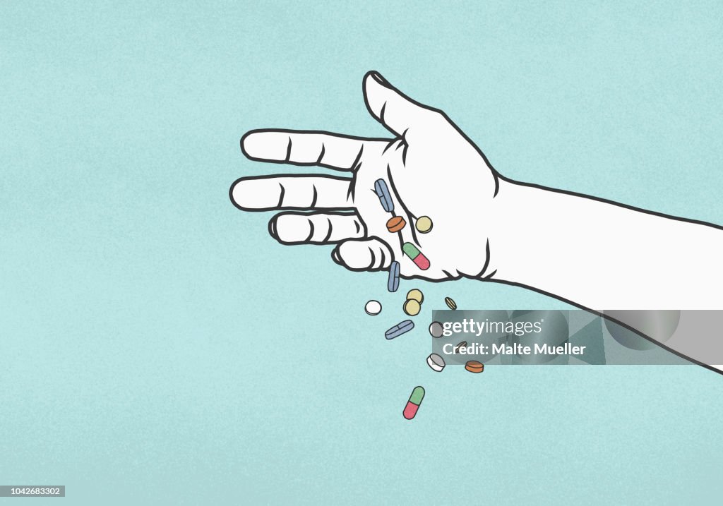 Hand dropping pills on blue background
