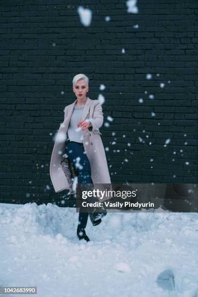 portrait young woman kicking snow - vladivostok city stock pictures, royalty-free photos & images