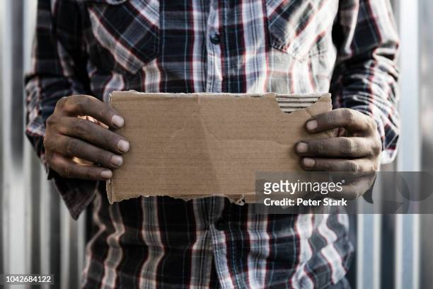 homeless man holding cardboard sign - homeless person imagens e fotografias de stock