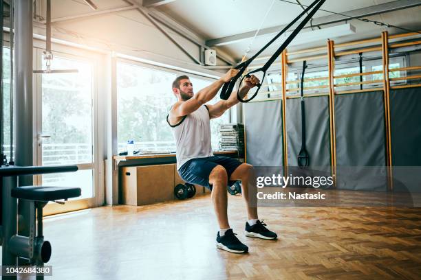 young man workout with trx suspension - suspension training stock pictures, royalty-free photos & images