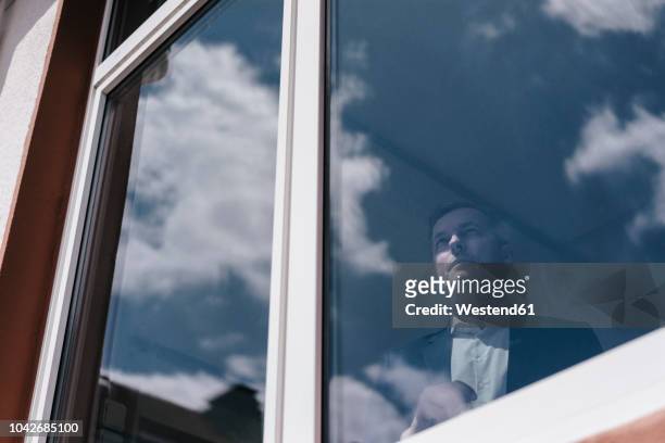 businessman looking out of window - büro und wolke stock-fotos und bilder