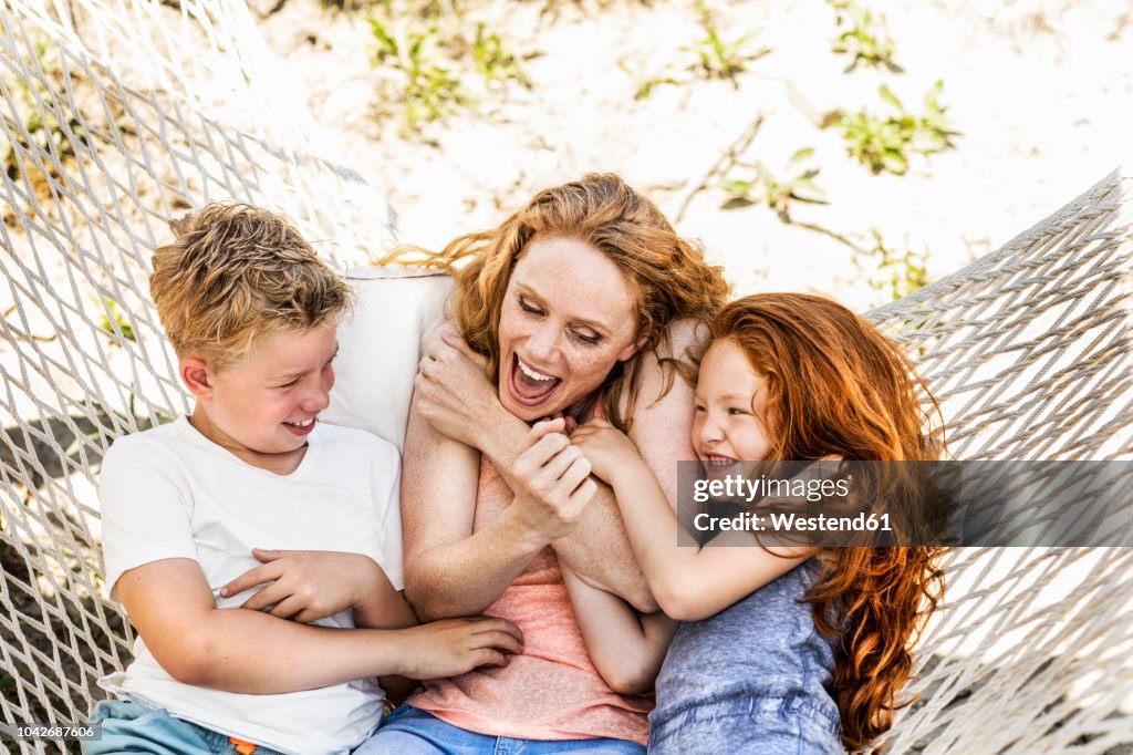 Happy mother with children in hammock