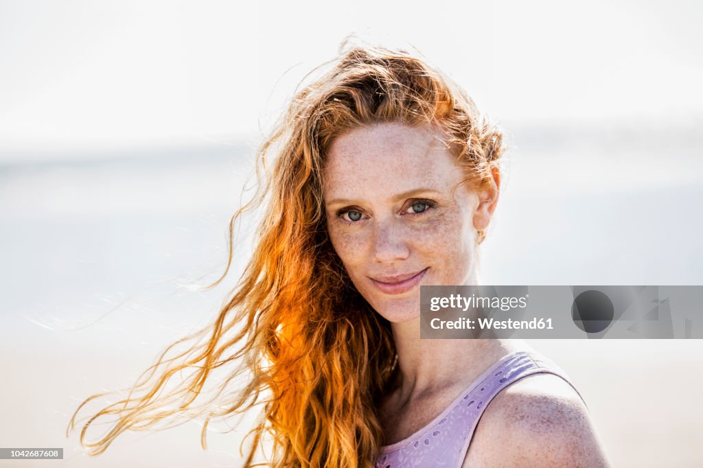 Portrait of smiling redheaded woman outdoors