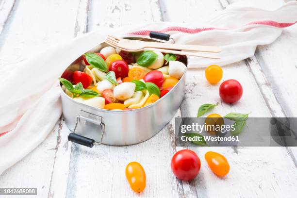 tortellini salad with tomato, mozzarella and basil in lunch box - cherry tomatoes stock-fotos und bilder