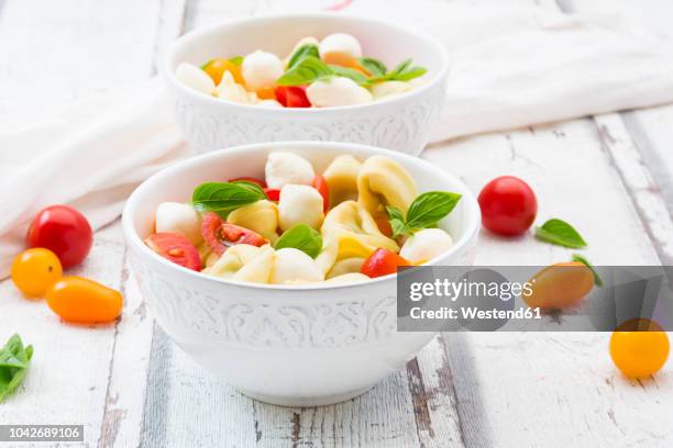 tortellini salad with tomato, mozzarella and basil - mozzarella stock pictures, royalty-free photos & images