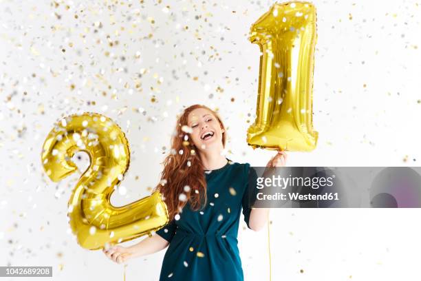 happy young woman with golden balloons celebrating her birthday - birthday balloon stock-fotos und bilder