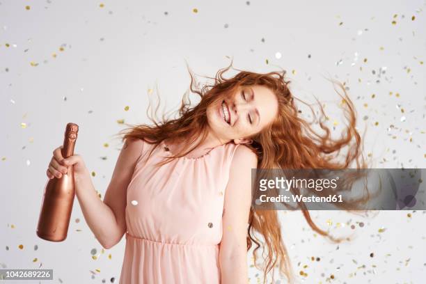 portrait of happy young woman dancing with bottle of champagne - performer fotografías e imágenes de stock
