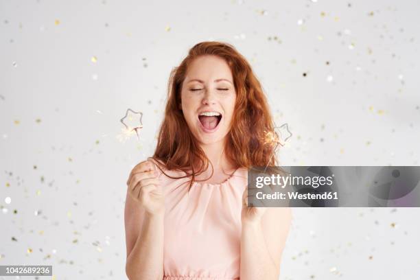 portrait of shouting young woman with two sparklers - beautiful redhead stock pictures, royalty-free photos & images