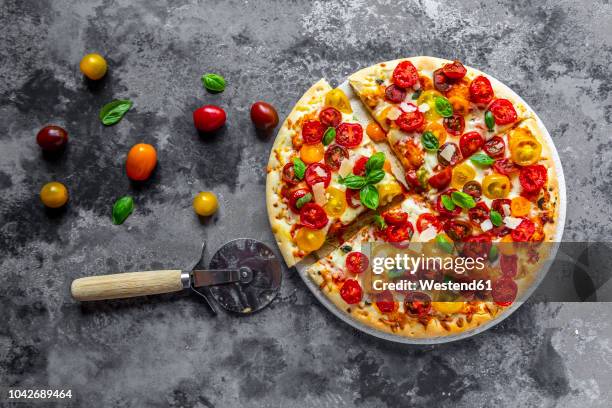 sliced pizza with tomatoes and basil leaves - イエロートマト ストックフォトと画像