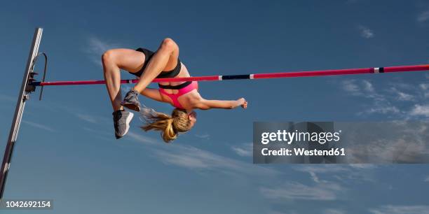 female high jumper, worm's eye view - track and field event stock pictures, royalty-free photos & images