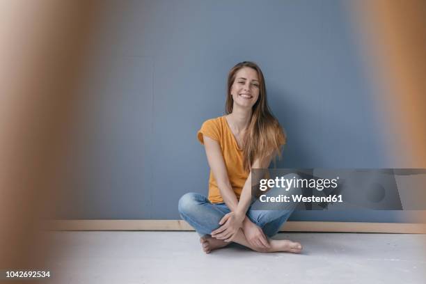 happy woman sitting on ground, barefoot with legs crossed, laughing - 胡坐　横 ストックフォトと画像