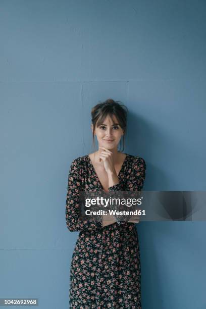 woman with flower dress leaning against wall, portrait - floral pattern dress stock pictures, royalty-free photos & images