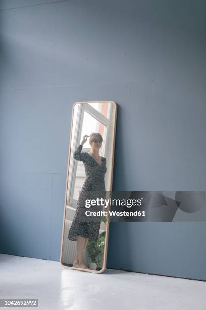 young woman in vintage dress looking into mirror - woman-looking-into-mirror-full-body stock pictures, royalty-free photos & images