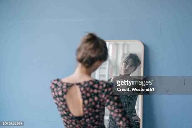 young woman in vintage dress looking into mirror - perfezione foto e immagini stock
