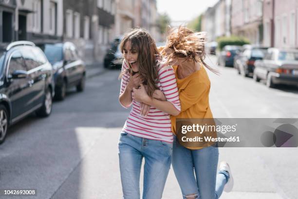 two girlfriends having fun in the city, running - friends laughing stock-fotos und bilder