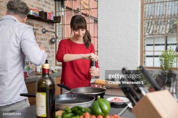 couple in kitchen, preparing food toghether - middle aged couple cooking stock-fotos und bilder